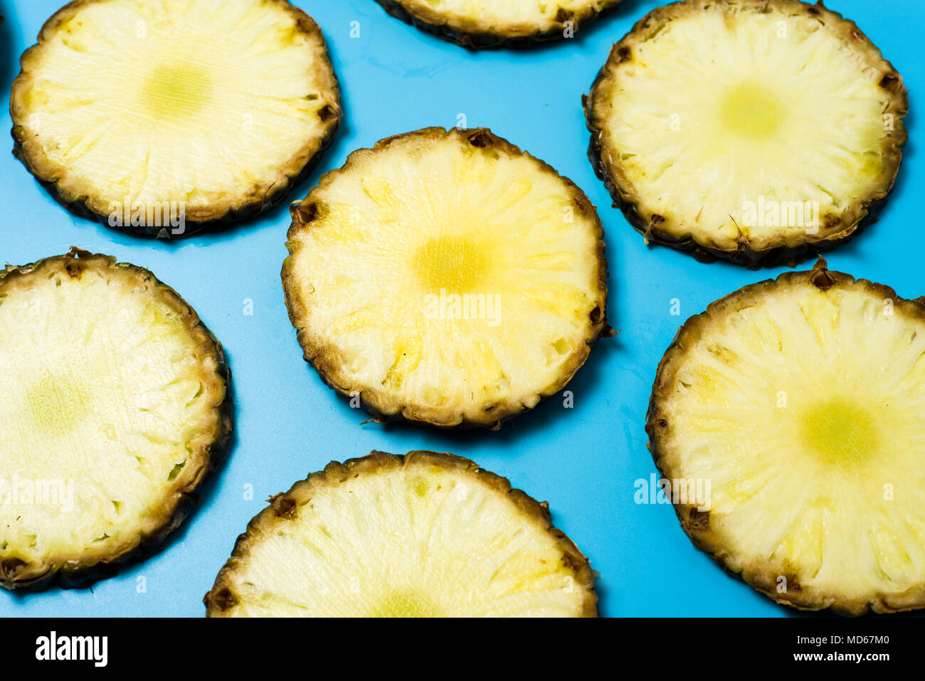 Ananasscheiben auf blauem Hintergrund flach Muster Stockfoto