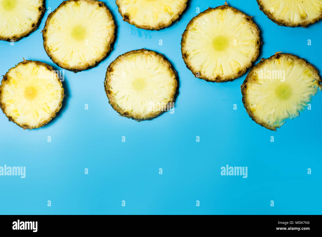 Ananasscheiben auf blauem Hintergrund flach Muster Stockfoto