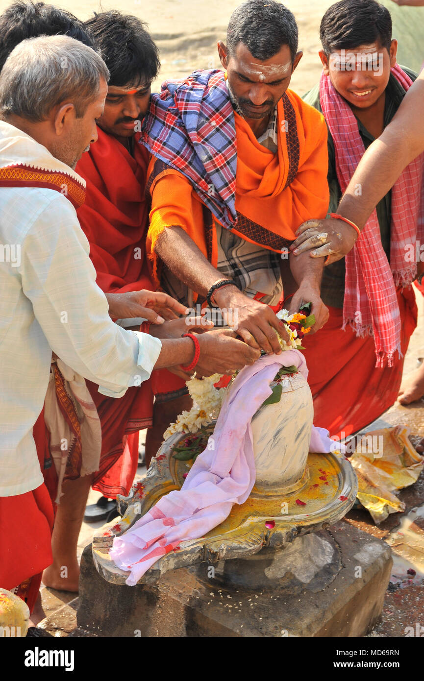 Männer stellen eine Blume Girlande auf einem geschmückten Shiva lingum Maha Shivaratri in Varanasi zu feiern. Stockfoto