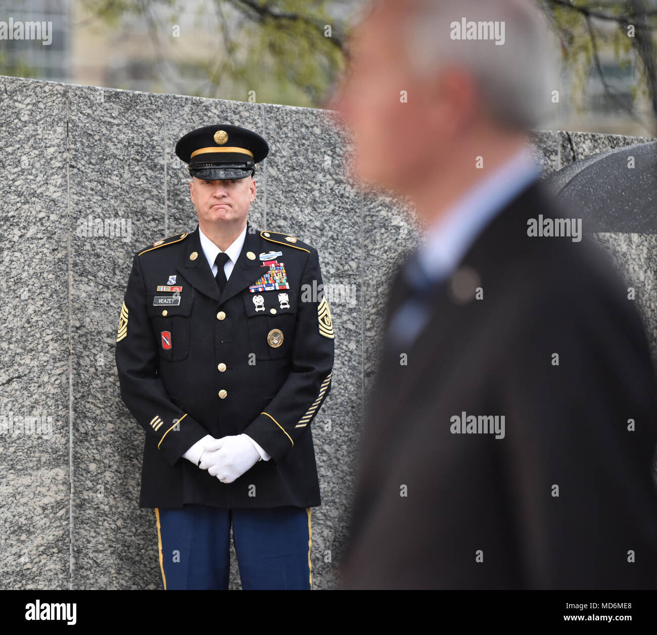 Little Rock, Arche: - Arkansas National Guard älterer Soldat Führer, Command Sergeant Major Steven Veazey hört als Arkansas Gouverneur Asa Hutchinson während einer Arkansas Abteilung der Veterans Affairs Kranzniederlegung Donnerstag, März 28, 2018 spricht, an der Vietnam Veterans' Denkmal auf dem Gelände des Arkansas State Capitol, die Zeremonie geehrt SGT Willie Pippins Sr. (Little Rock, AR) und SPC Glennon Marcussen (Monticello, AR). Beide Pippins" und marcussen Die Namen sind auch auf das Vietnam Memorial in Washington DC. (U.S. Army National Guard Foto von Civ. Zac Lehr) Stockfoto