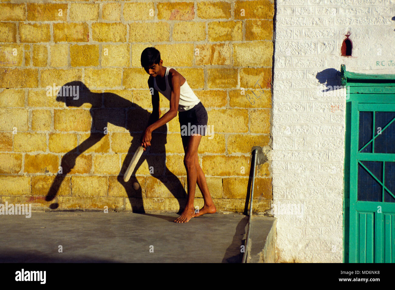 Jaisalmer, Indien; Junge spielt Straße Kricket. Mit Abstand der populärste Sport in Indien, Cricket ist ein multi-million Dollar Industrie. Stockfoto