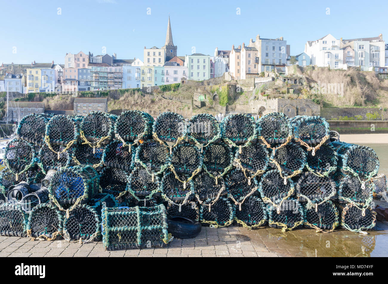 Fischer Krabben und Hummer Töpfe stapelten sich auf dem Kai am Hafen von Tenby in Pembrokeshire, Wales Stockfoto