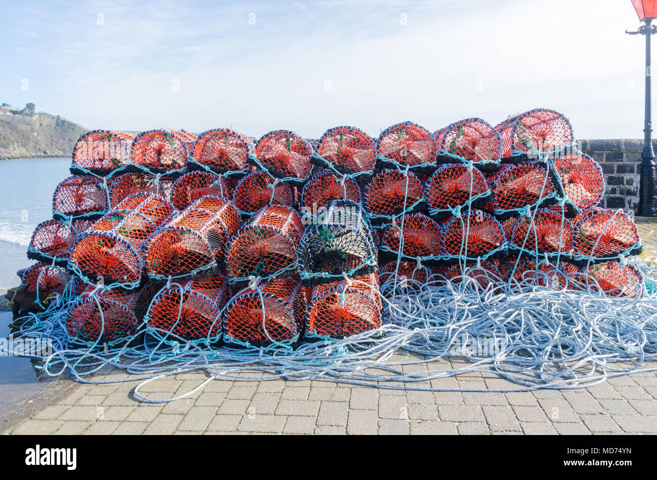 Fischer Krabben und Hummer Töpfe stapelten sich auf dem Kai am Hafen von Tenby in Pembrokeshire, Wales Stockfoto