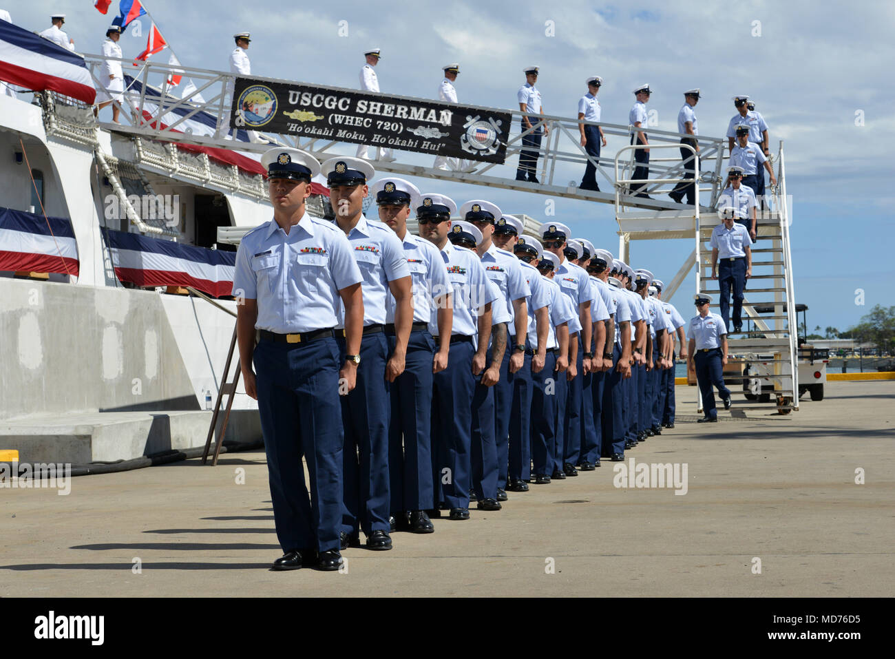 Coast Guard Cutter Sherman Crewmitglieder legen an Land während des Sherman Stilllegung Zeremonie in Honolulu, März 29, 2018. Die Sherman war der letzte noch aktive Küstenwache Kriegsschiff ein feindliches Schiff im Kampf versenkt haben, wenn die Besatzung eines Nordvietnamesischen marine Trawler während des Vietnam Krieges sank durch Brennen von acht Runden von seinen 5 "gun in 30 Sekunden. U.S. Coast Guard Foto von Petty Officer 1st Class Matthew S. Masaschi. Stockfoto