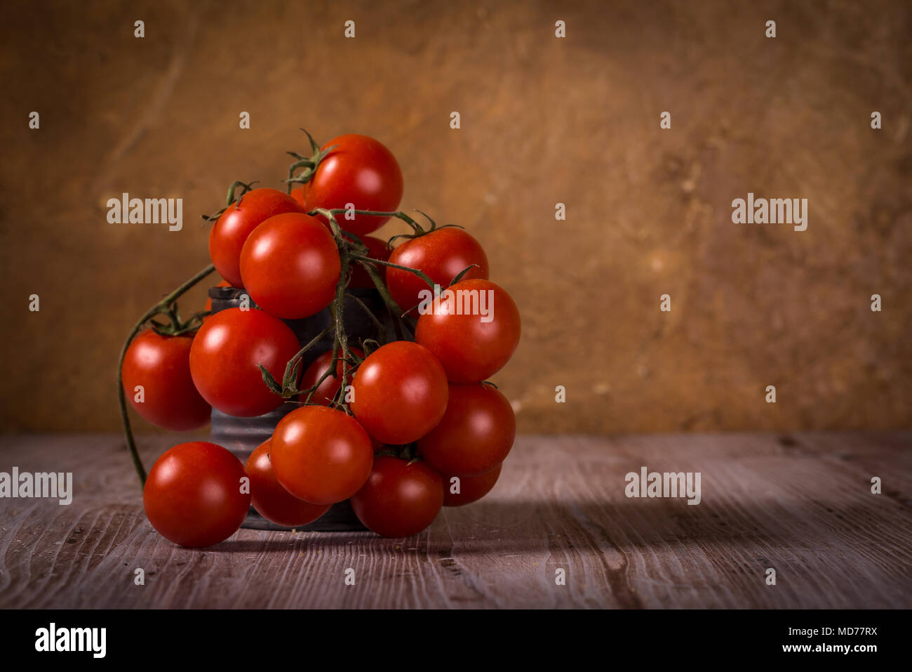 Horizontale Foto mit wenigen Zweige voller kleiner roter Kirsche Tomaten. Gemüse in Vintage getragen werden kann. Zinn ist auf Holzbrett mit weißen und braue Stockfoto