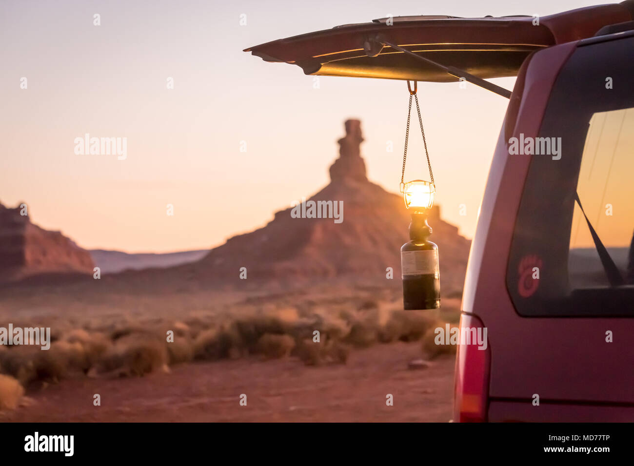 Eine leuchtende Laternen hängt von der Hintertür eines roten SUV in der Wüste im südlichen Utah. Stockfoto