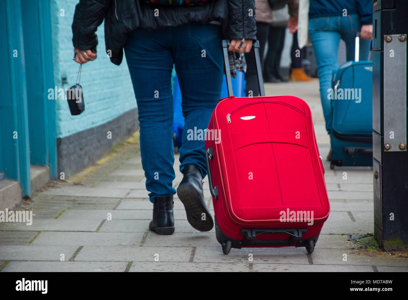 Cambridge, UK, 15. April 2018. Man Walking mit Trailing red Fall auf Rädern entlang Weg. Stockfoto Cambridge, UK, 15. April 2018. Man Walking mit Trailing red Fall auf Rädern entlang Weg. Stockfoto