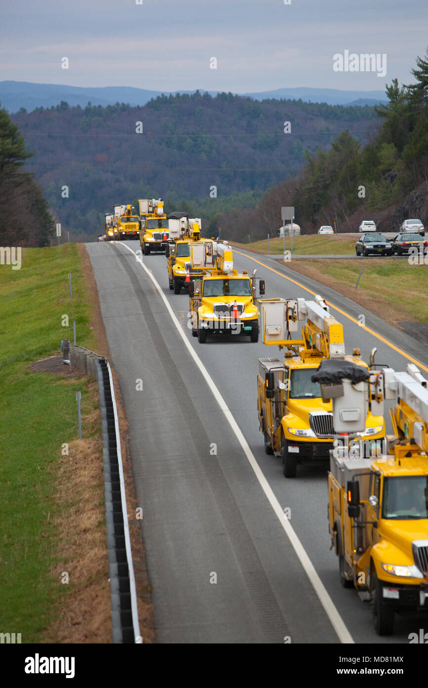 Ein Konvoi von Gelb electric utility Trucks, die sich in der Ausbildung in Richtung Süden mit Hurrikan Schäden Bereinigung für Hurrikan Sandy zu unterstützen. Stockfoto