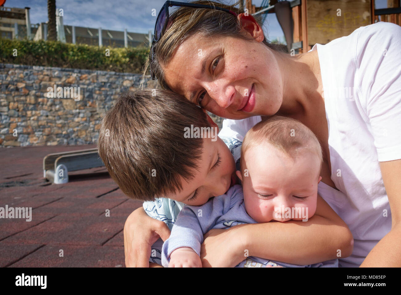 Porträt der Mutter mit zwei Söhnen am Spielplatz, Griechenland Stockfoto