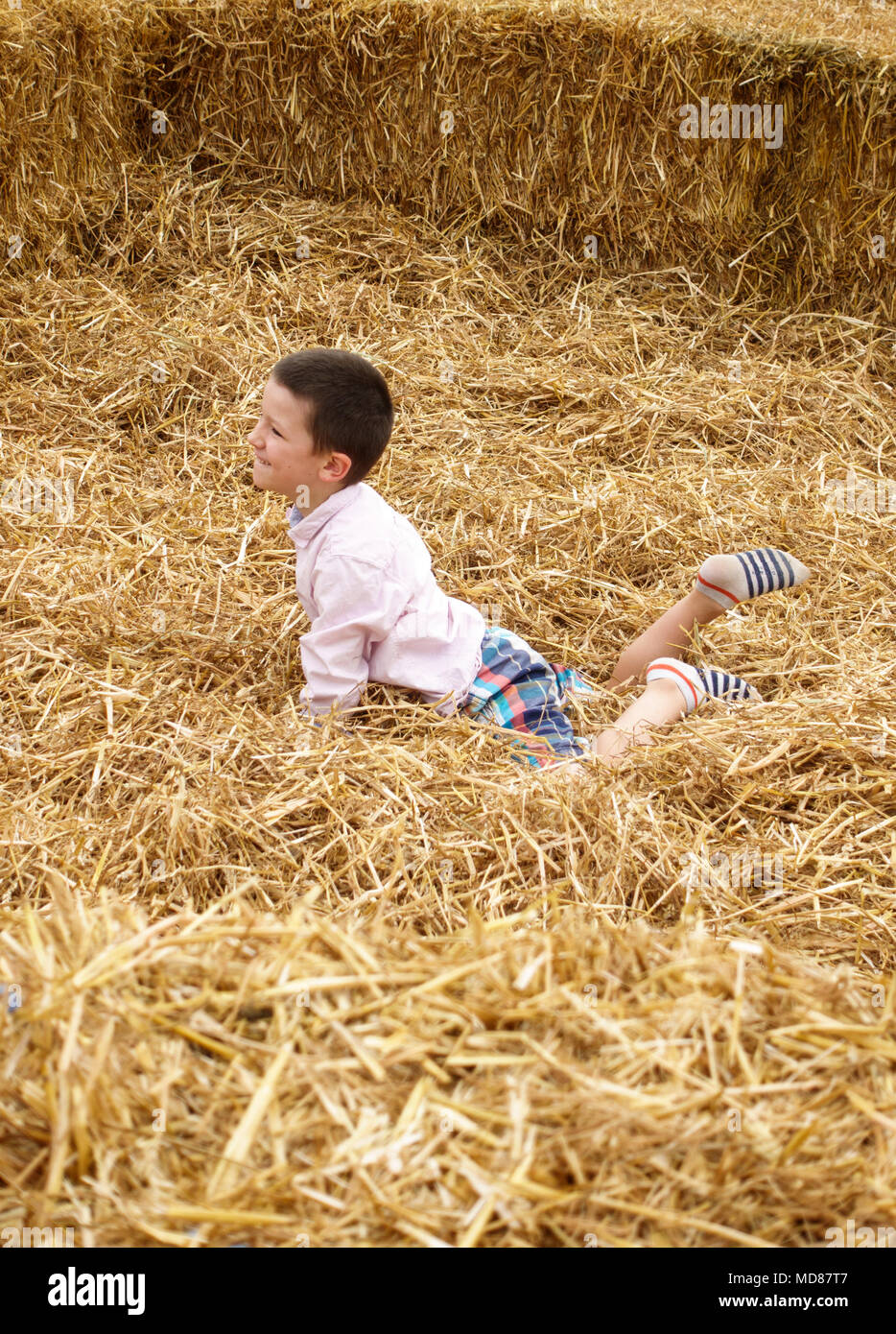 Junge liegend auf Heuhaufen Stockfoto
