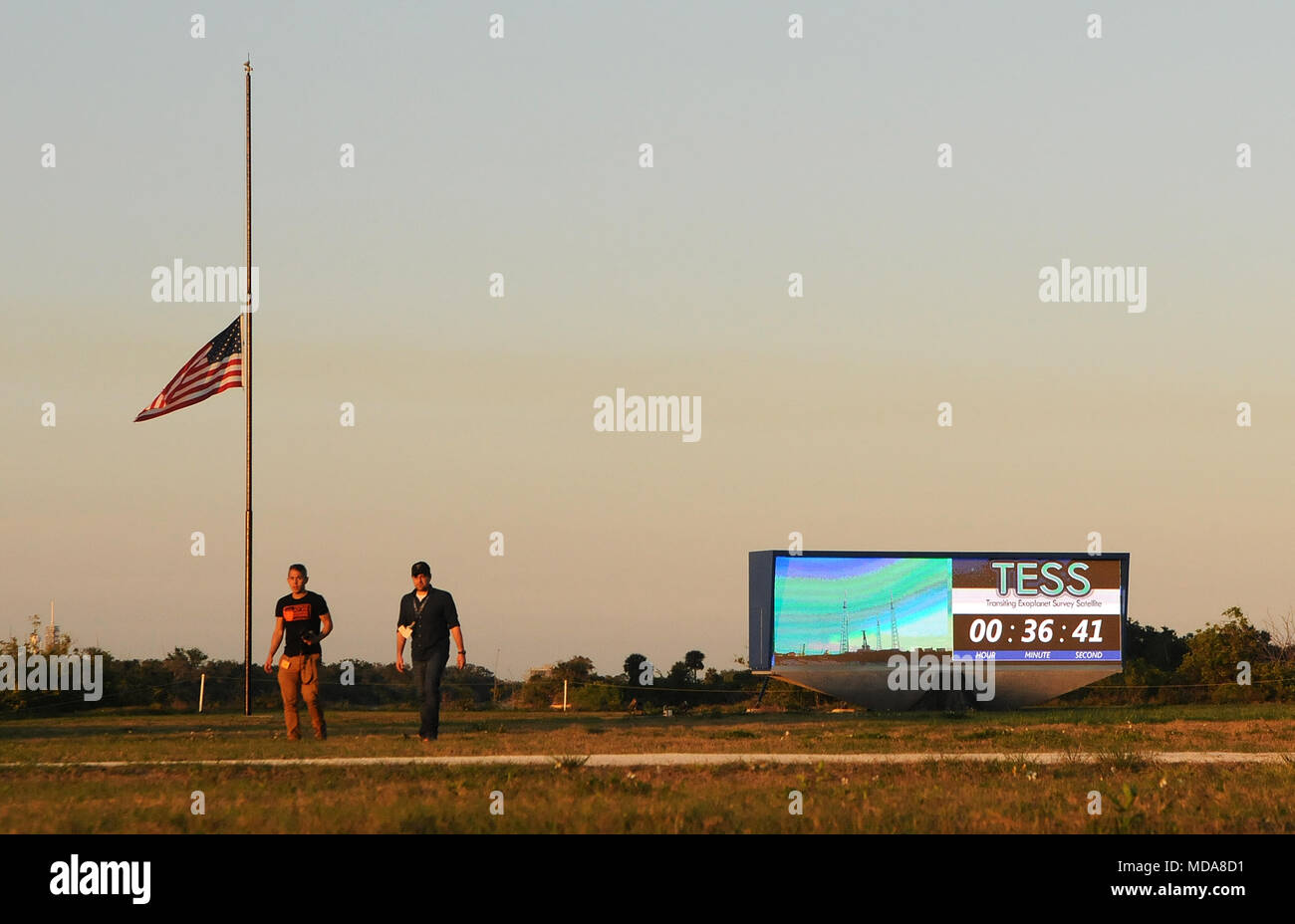 April 18, 2018 - Kennedy Space Center, Florida, Vereinigte Staaten - Nach der Einführung von SpaceX der NASA-Satelliten Transit Exoplanet Survey (TESS) der Cape Canaveral Air Force Station, eine US-Flagge zu sehen ist das Fliegen an der Hälfte - Neben der NASA-Countdown Uhr am Kennedy Space Center in Florida am April 18 Mitarbeiter, 2018 zu Ehren des ehemaligen First Lady Barbara Bush, der gestern im Alter von 92 Jahren gestorben. TESS ist auf eine zweijährige Mission zum Planeten außerhalb unseres Sonnensystems zu suchen. (Paul Hennessy/Alamy) Credit: Paul Hennessy/Alamy leben Nachrichten Stockfoto