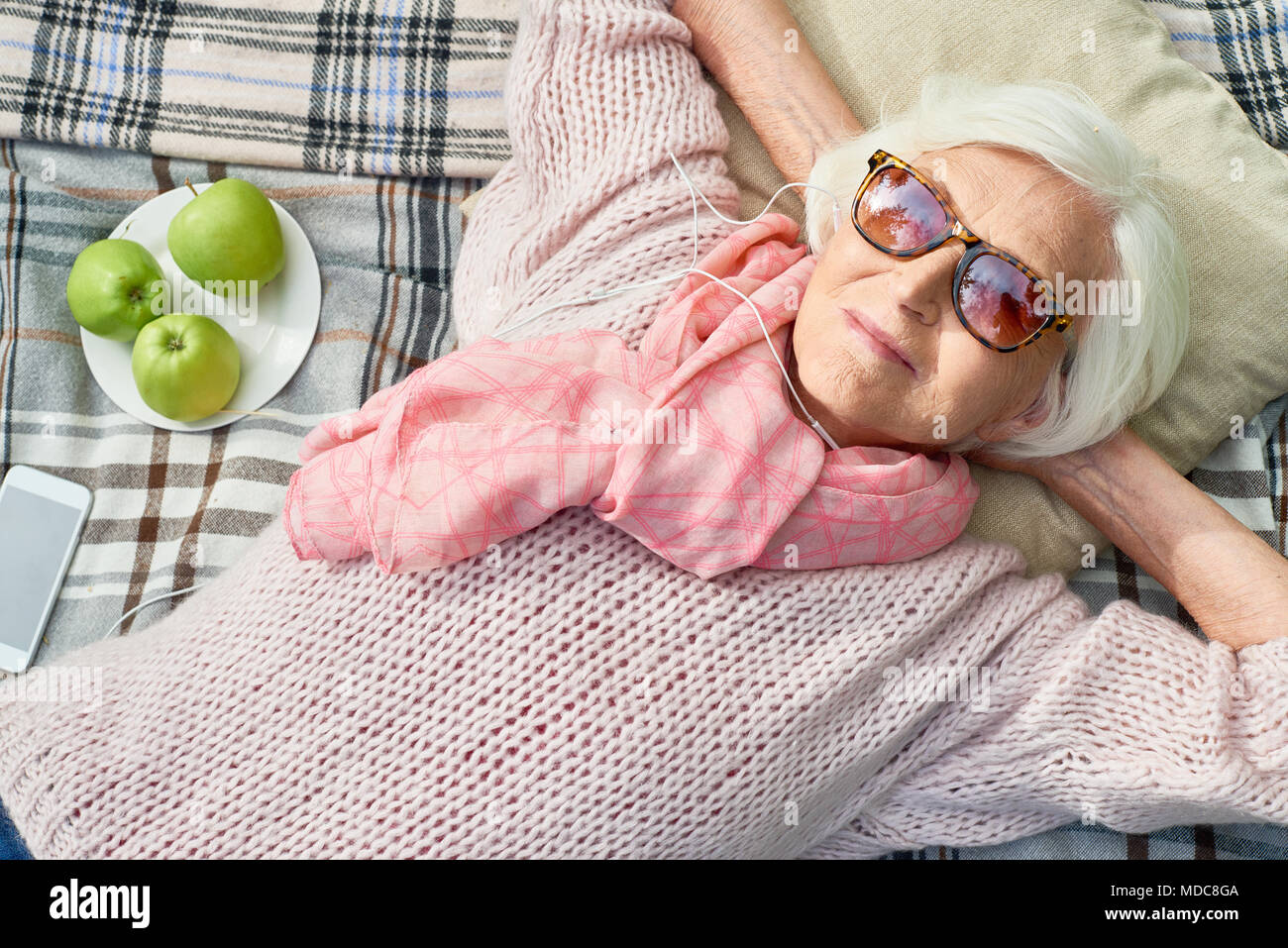 Gerne ältere Frau Hören von Musik im Picnic Stockfoto