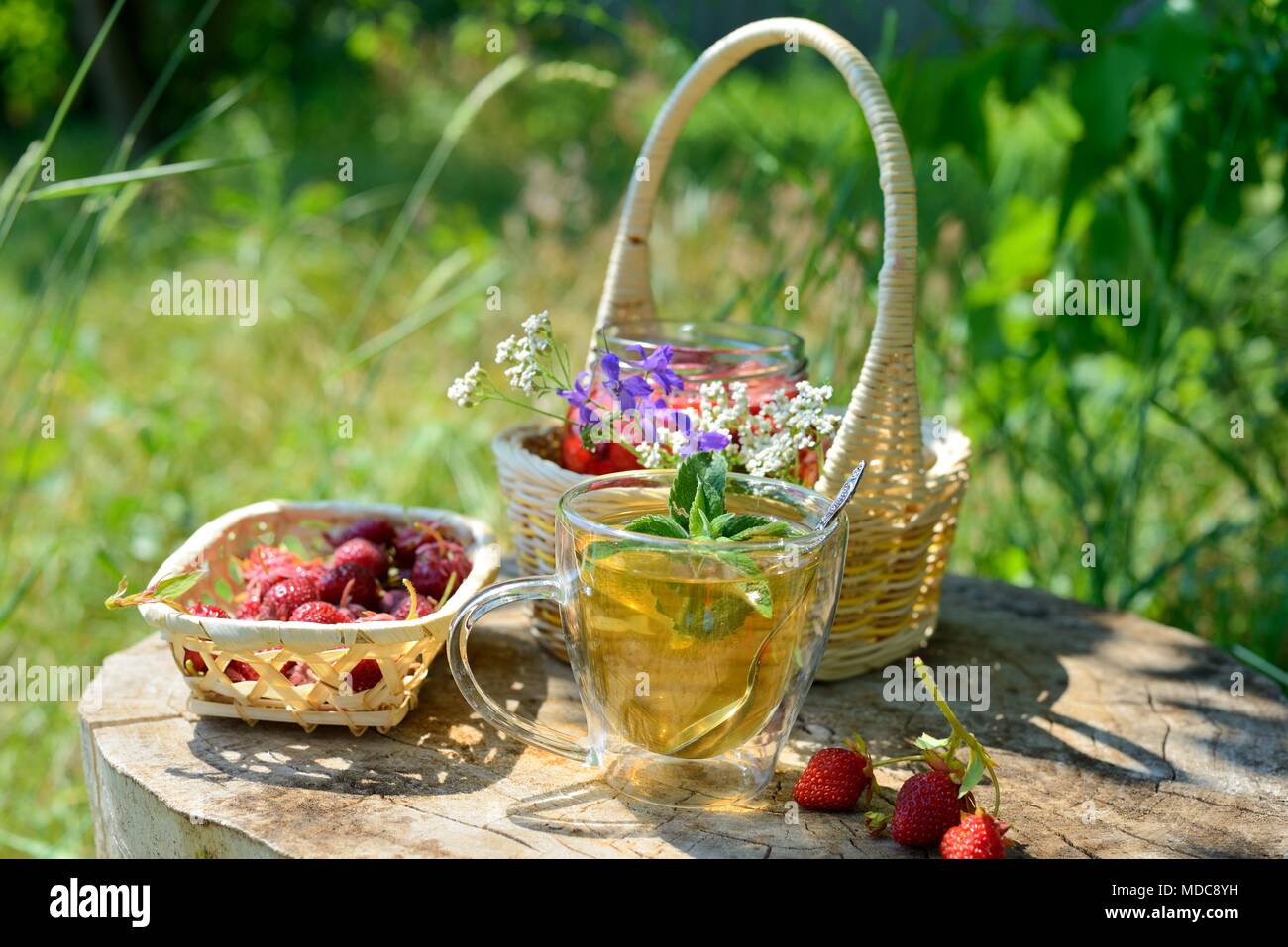 Still-Leben im Freien: einen Korb mit Erdbeeren und Marmelade Stockfoto