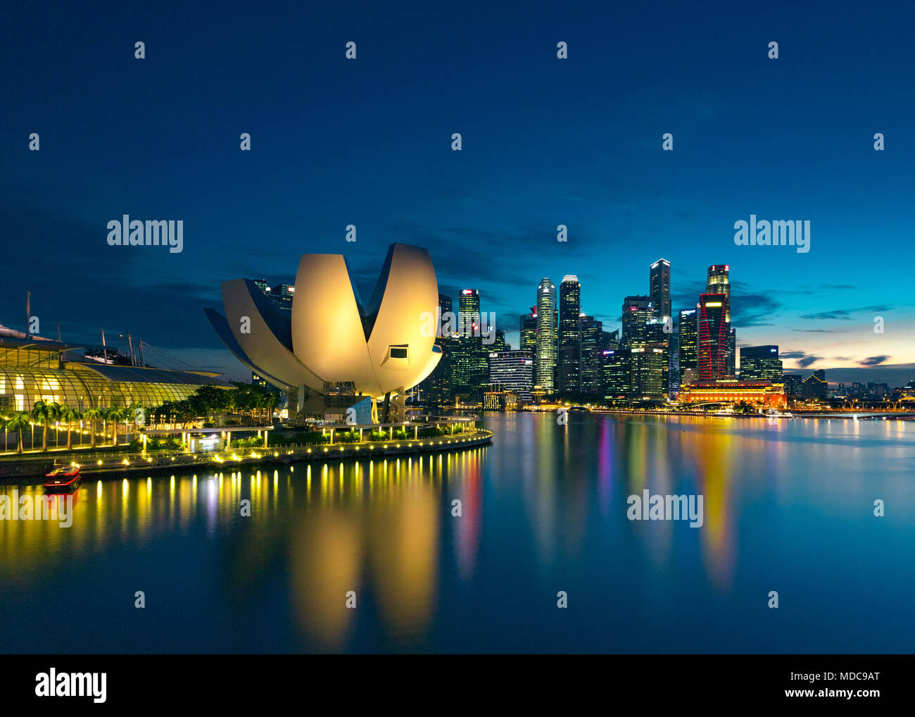 Waterfront Wolkenkratzer und beleuchtete Gebäude von ArtScience Museum bei Nacht, Singapur Stockfoto