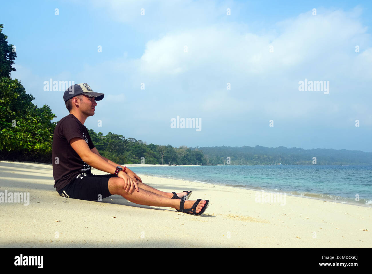 Mann sitzt auf tropischen Strand mit Blick auf den Ozean. Havelock Island ist eine wunderschöne kleine Insel, die zu den indischen Andaman Nicobar Inseln. P Stockfoto