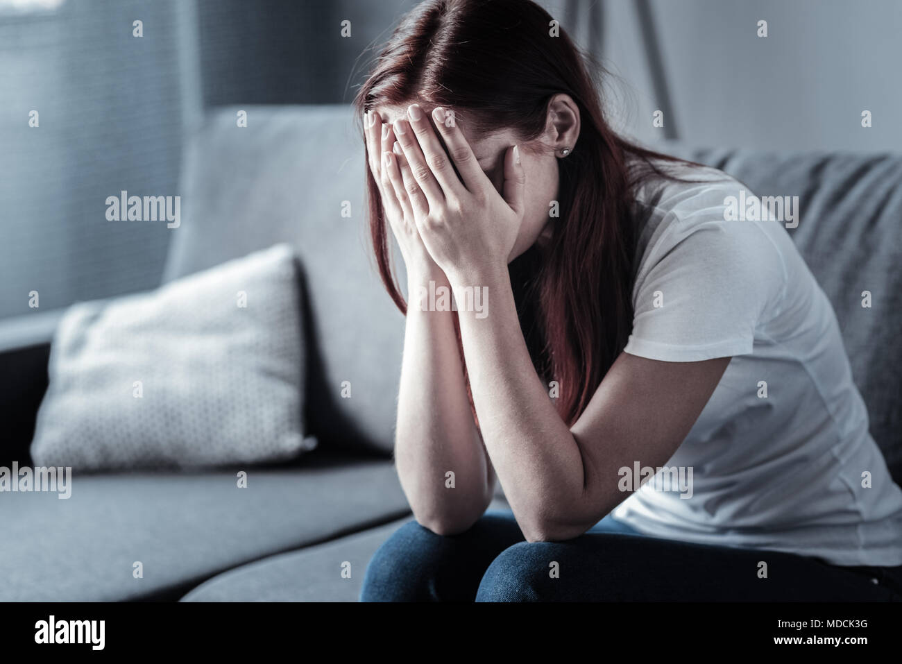Junge depressiven Frau, die ihr Gesicht verbergen Stockfoto