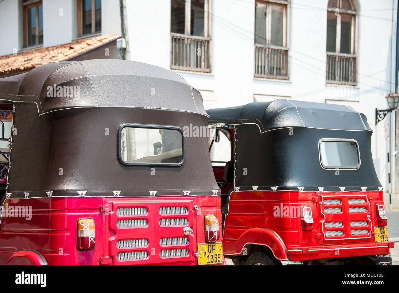 Ansicht der Rückseite des roten und schwarzen Tuktuk Taxis, in einem typischen Straßenbild, Galle, Sri Lanka Stockfoto