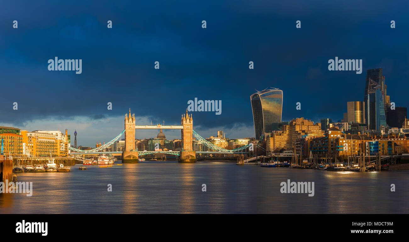 London, England - Schöne golden sunrise in London Tower Bridge, St. Paul's Kathedrale und den Wolkenkratzern der Bank District. Dramatische dunkle Wolken am Stockfoto