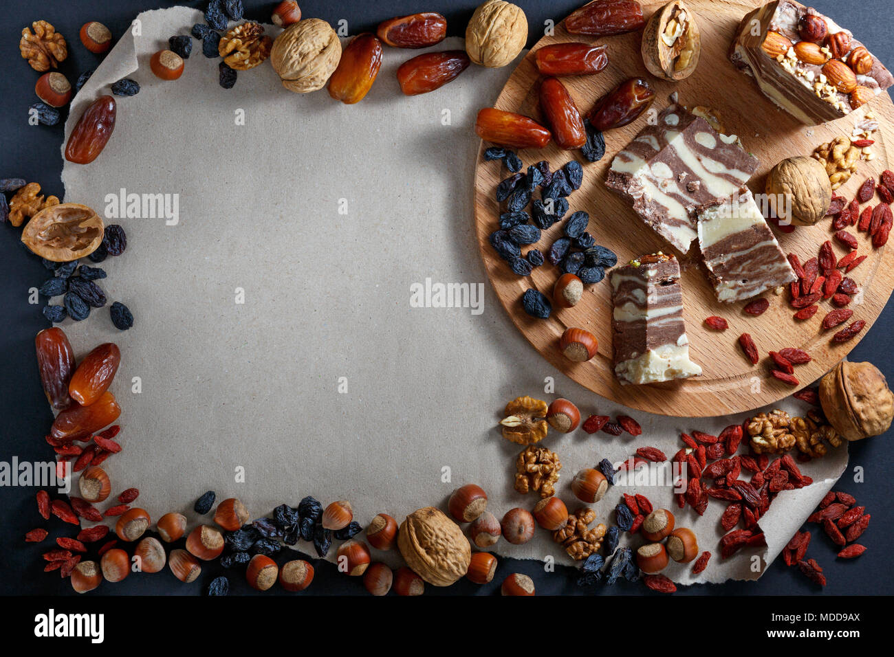 Mehrere Stücke von halvah, Nüsse und getrocknete Früchte essen Rahmen auf Papier Hintergrund mit Kopie Platz für Text Messaging. Ansicht von oben, kopieren Raum Stockfoto