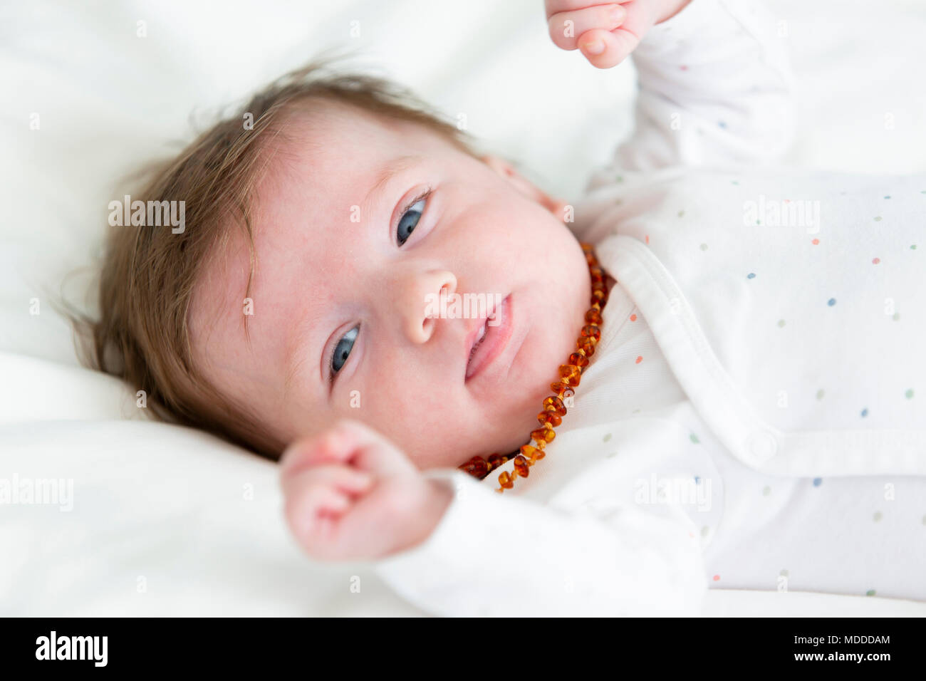 3 Monate alten schönen, niedlichen Baby mit Bernstein Halskette Stockfoto