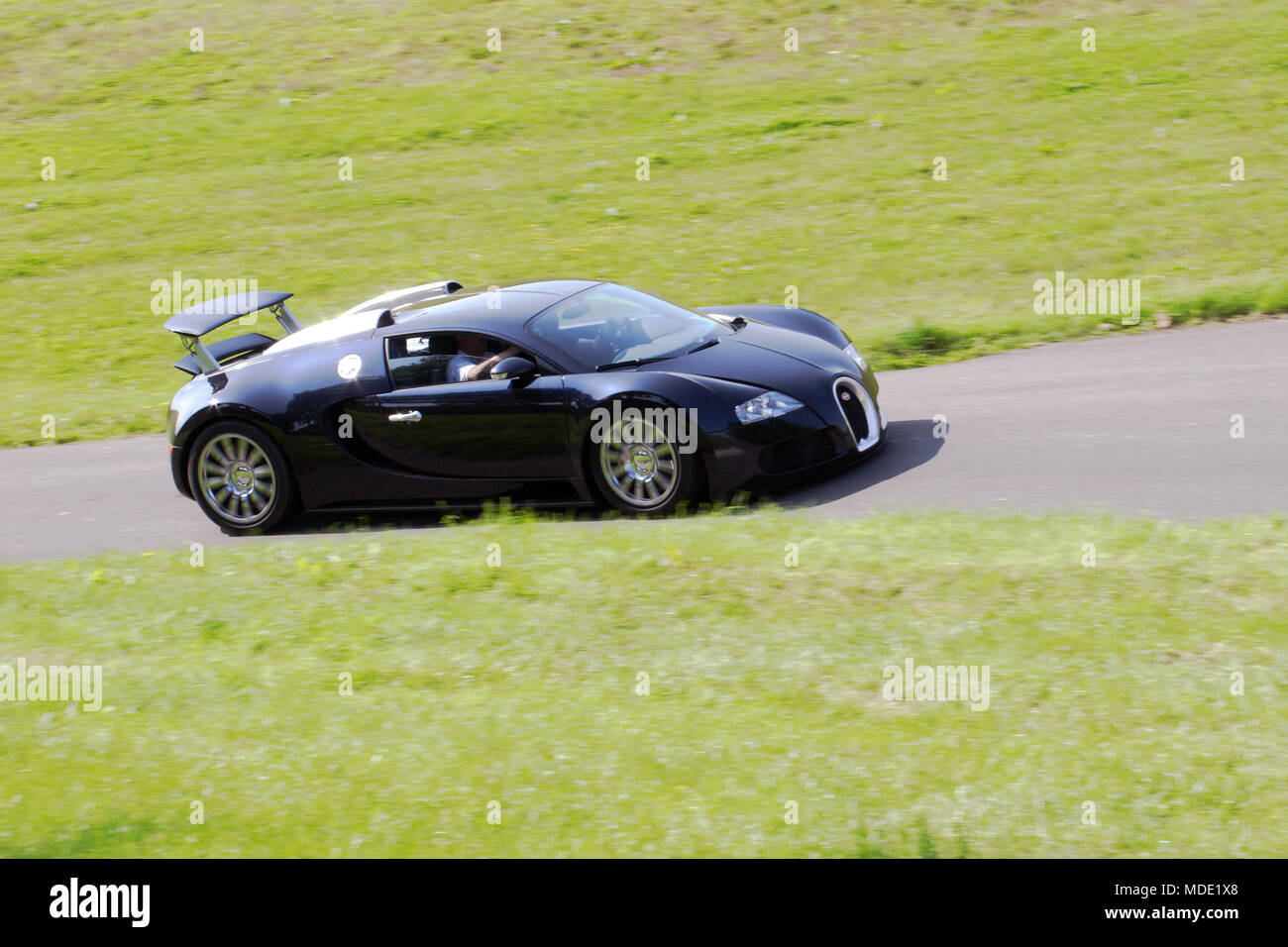 Schwarz Bugatti Veyron Mio. £ Pfund hyper Auto hypercar schnelles Fahren auf einer Landstraße. Stockfoto