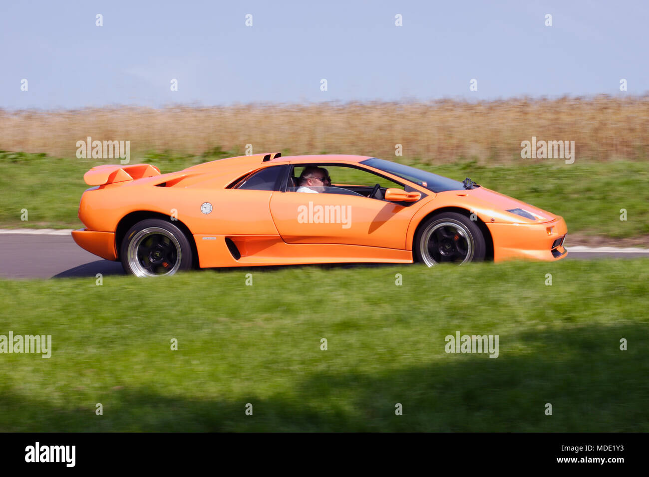 Fluoreszierend leuchtend orange Lamborghini Diablo GT V12 '90 s (1990s) supercar schnelles Fahren und Rennsport auf Schiene. Stockfoto