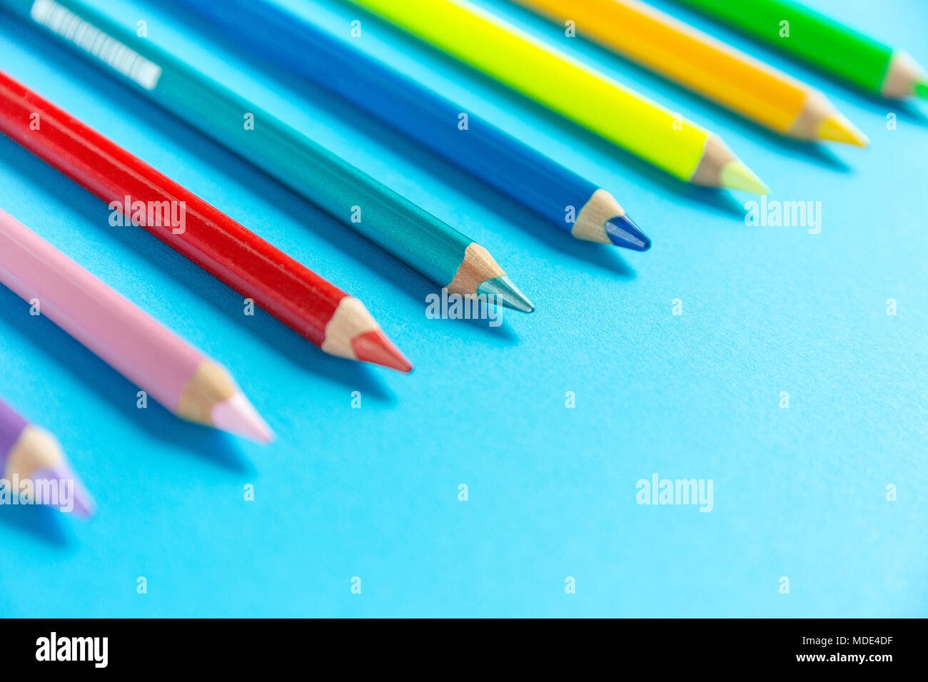 Verschiedene Farbstifte in einer Reihe auf einem Papier organisiert Stockfoto