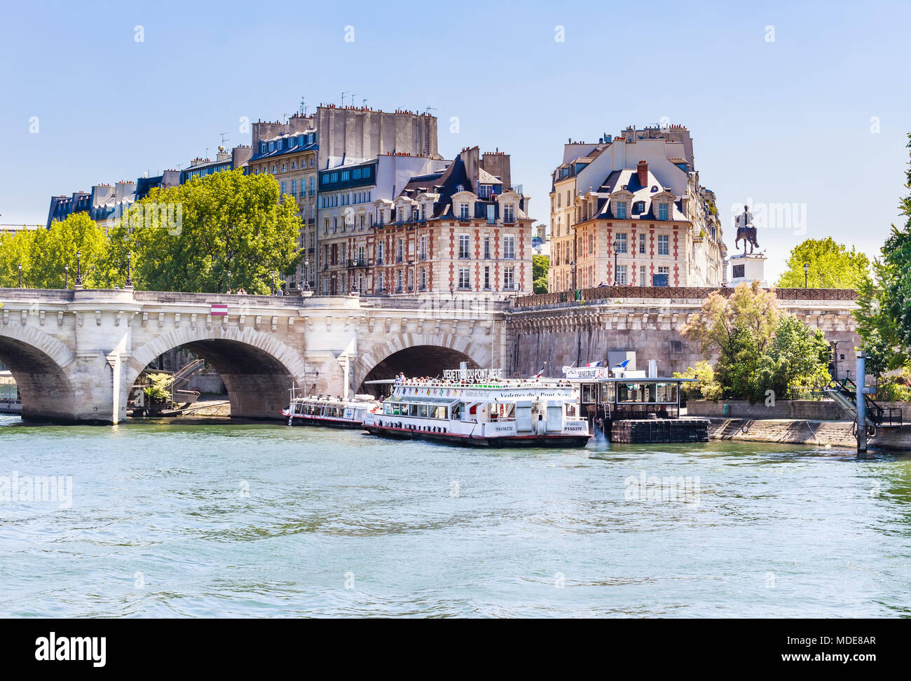 Die vedettes du Pont Neuf tour Boot auf der Seine in der Nähe einer Brücke. Reiterstandbild von Henri IV. Paris, Frankreich Stockfoto