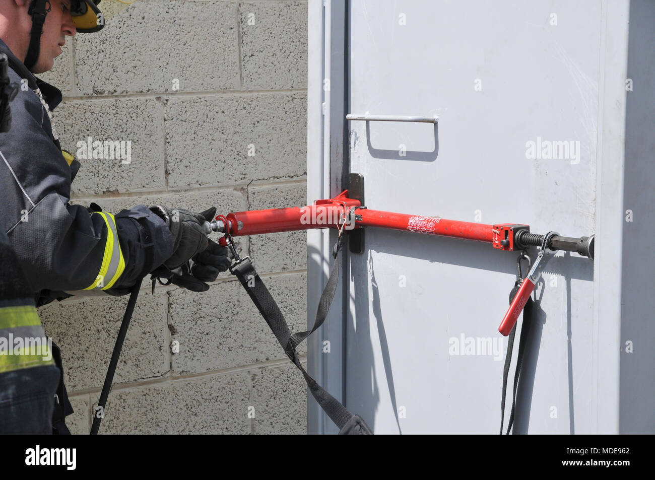 Fire Fighter verwendet hydraulische Werkzeuge eine verschlossene Tür zu Bruch Stockfoto