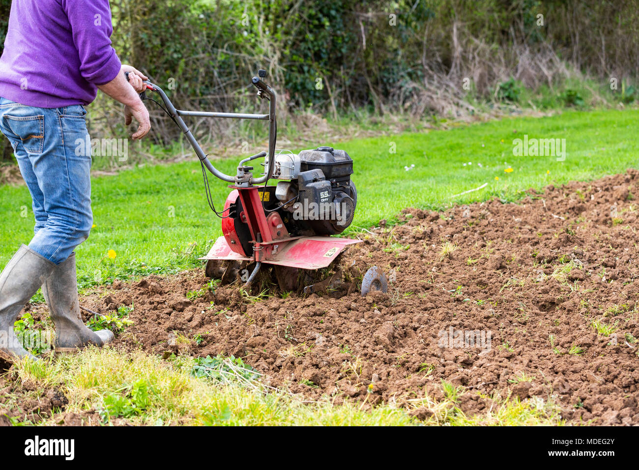 Senior Landwirt Gärtner im Garten arbeitet mit rototiller, Deichsel