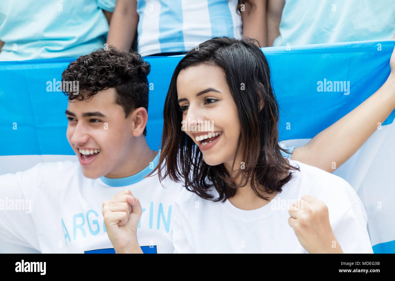 Gerne Fussball Fans aus Argentinien mit argentinischer Flagge im Freien bei Stadion Stockfoto