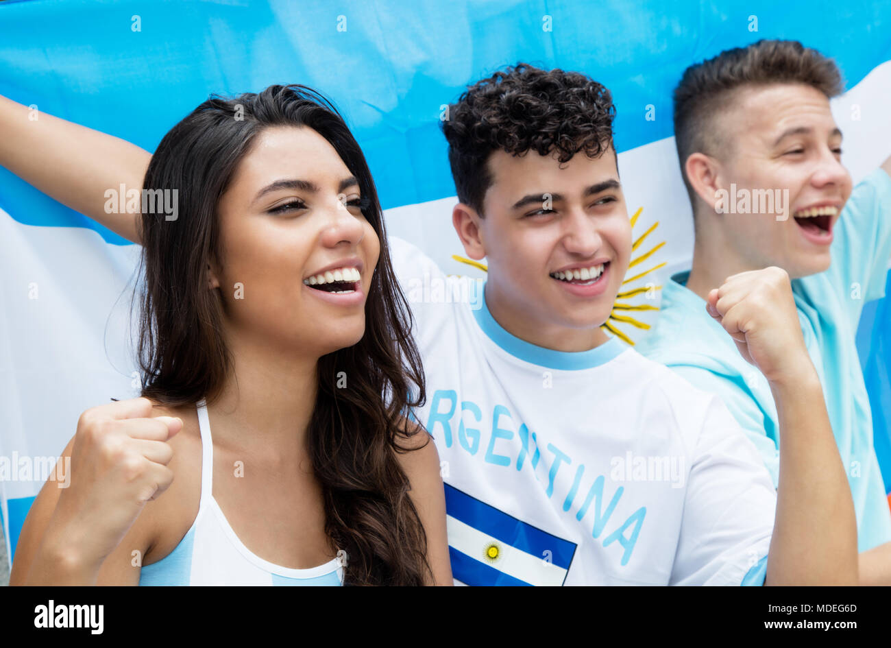 Jubelnde Fußballfans aus Argentinien im Stadion mit argentinischer Flagge Stockfoto