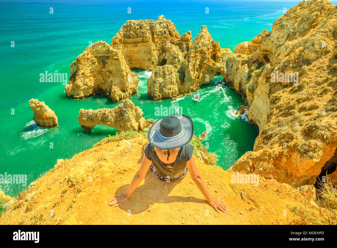 Tourismus in der Algarve. Sommer Urlaub in Portugal, Europa. Lifestyle Touristen sitzen auf der Landzunge Ponta da Piedade. Kaukasische Frau suchen erstaunliche Ansichten der berühmten Klippen von türkisblauen Meer von Lagos. Stockfoto