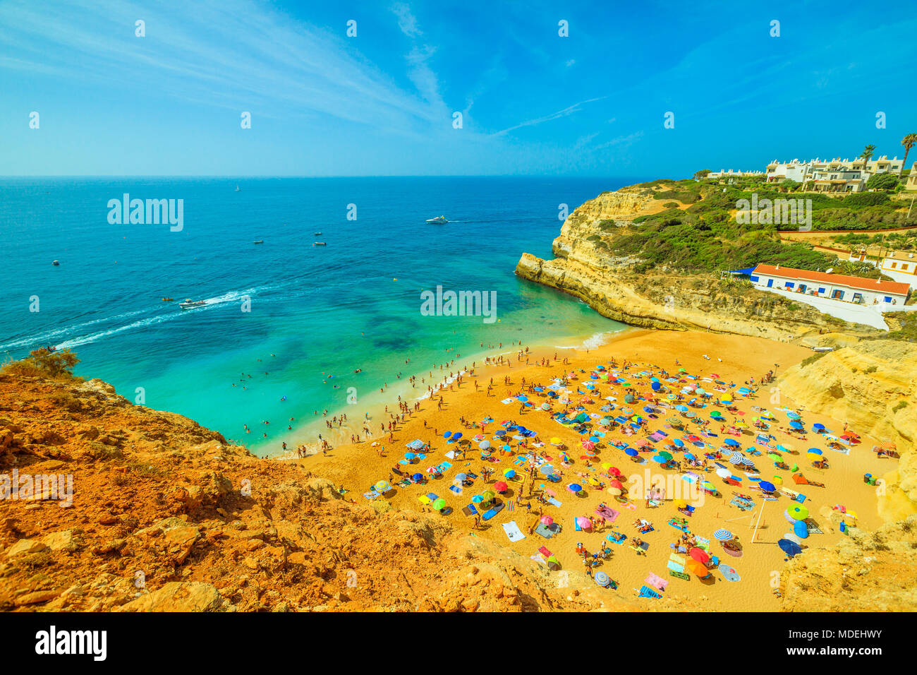 Luftaufnahme von Golden-farbigen Klippen von Praia De Benagil in der Nähe von Lagoa, Algarve, Portugal, Europa. Touristen Sonnen in berühmten Benagil Strand bekannt für eine beeindruckende Höhle, bekannt als Algar De Benagil. Stockfoto