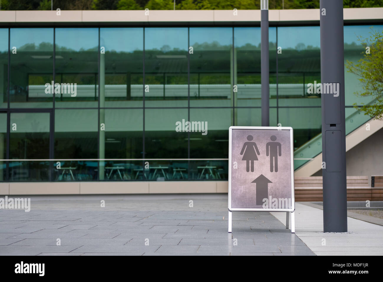 Große mens und der Badezimmer Wegbeschreibung auf der außerhalb von, was möglicherweise eine Universität oder Firma Gebäude Stockfoto