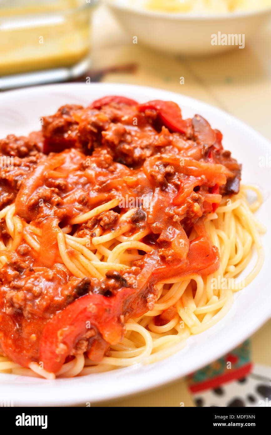 Eine Platte mit gekochten Spaghetti Bolognese gemacht mit Angel Hair Pasta auf dem Esstisch. Stockfoto