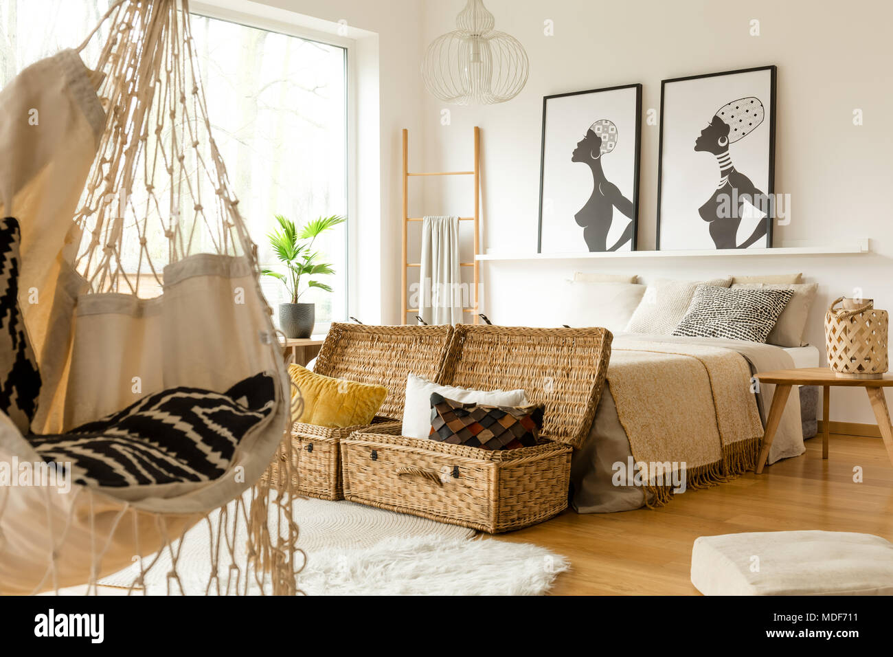 Afrikanische Schlafzimmer Innenraum mit einer Schaukel, Boxen mit Kissen,  Doppelbett und Poster Stockfotografie - Alamy