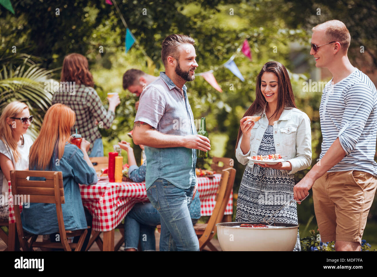 Student Freunde reden über einen Grill während einer Gartenparty im Sommer Stockfoto