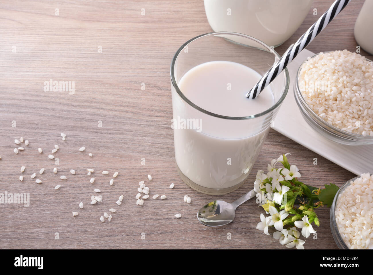 Reis Milch und Reis im Behälter auf einem Holztisch in rustikale Küche. Alternative Milch. Erhöhte anzeigen. Horizontale Zusammensetzung Stockfoto