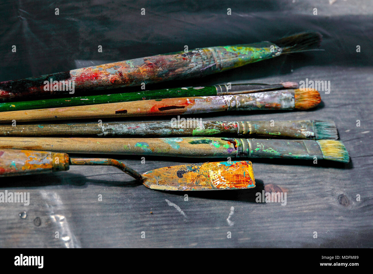 Palettenmesser und Bürsten auf Palette eines Künstlers Stockfoto