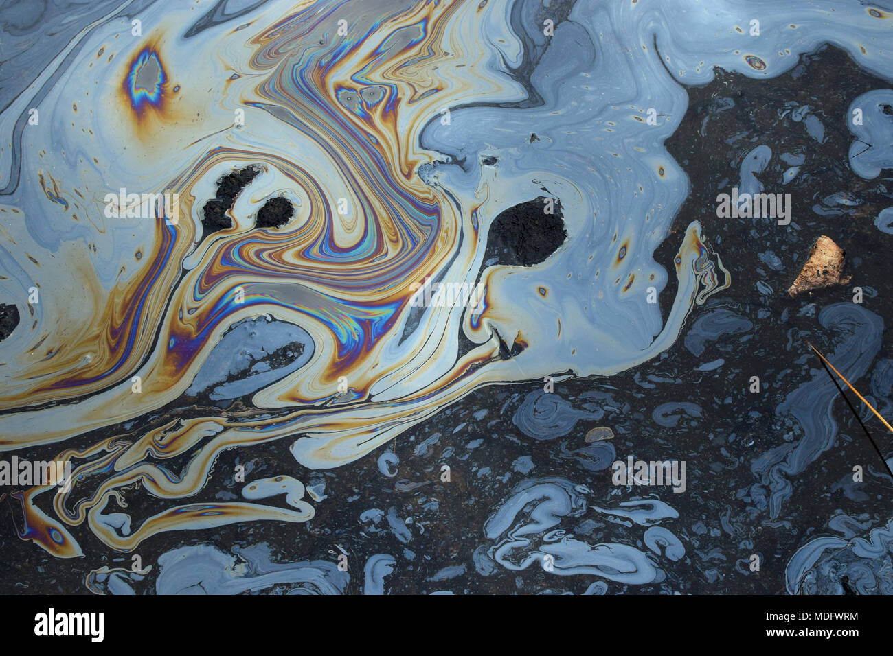 Schillernde Farben, abstrakte Formen auf Teer Wasserfläche von naturasphalt Grube. Stockfoto