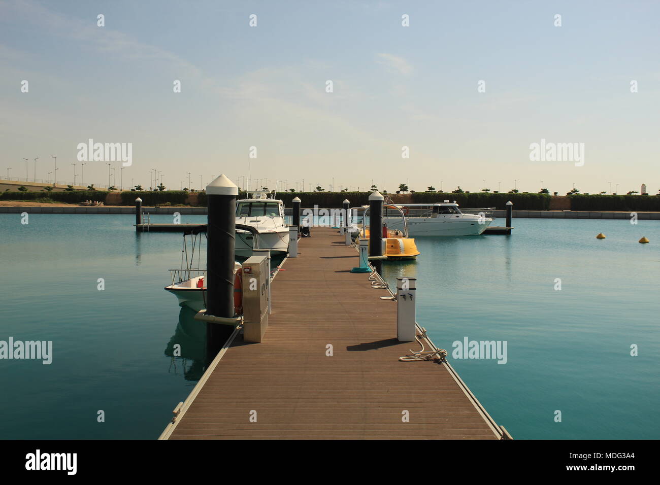 Einen schönen und modernen Blick auf einen kleinen Hafen, geparkt mit Boote und Yacht. Einen Nachmittag Blick auf das ruhige Wasser, mit den Gehweg perfekt ausgerichtet. Stockfoto