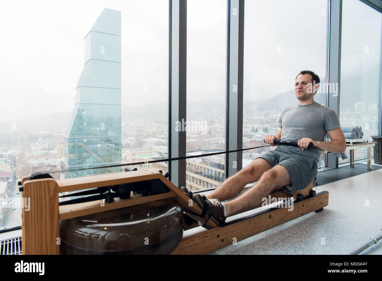 Menschen, die auf der Maschine im Fitness Studio bei scyscraper Luxus Hotel Fitnessraum Stockfoto