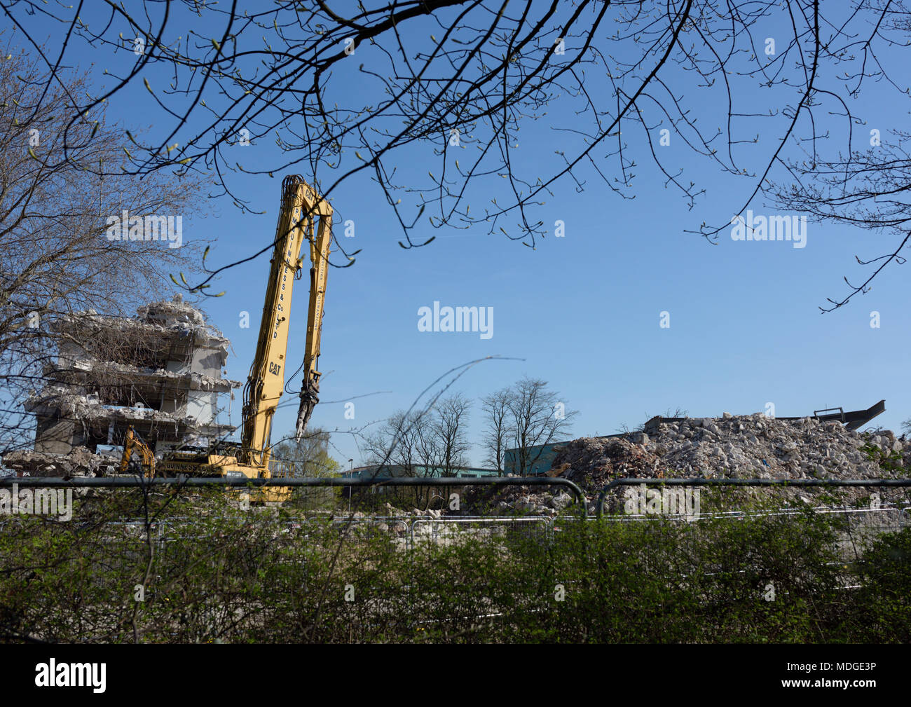 Caterpillar 350 L hoch reichender Abbruchbagger mit Betonbrecherbefestigung vor dem teilweise abgerissenen Betongebäude, Bury lancashire uk Stockfoto