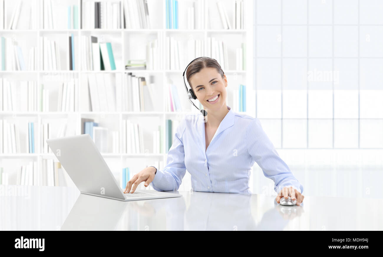 Business lächelnde Frau oder eine Sekretärin in Ihrem Büro Schreibtisch mit Computer und das Arbeiten mit der Sprechgarnitur, Kontakt und Support Konzept Stockfoto