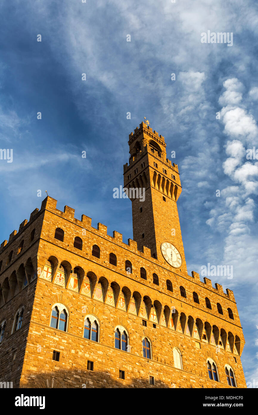 Alte steinerne Burg und Turm mit dramatischen Wolken und blauer Himmel orange leuchtende bei Sonnenuntergang; Florenz, Toskana, Italien Stockfoto