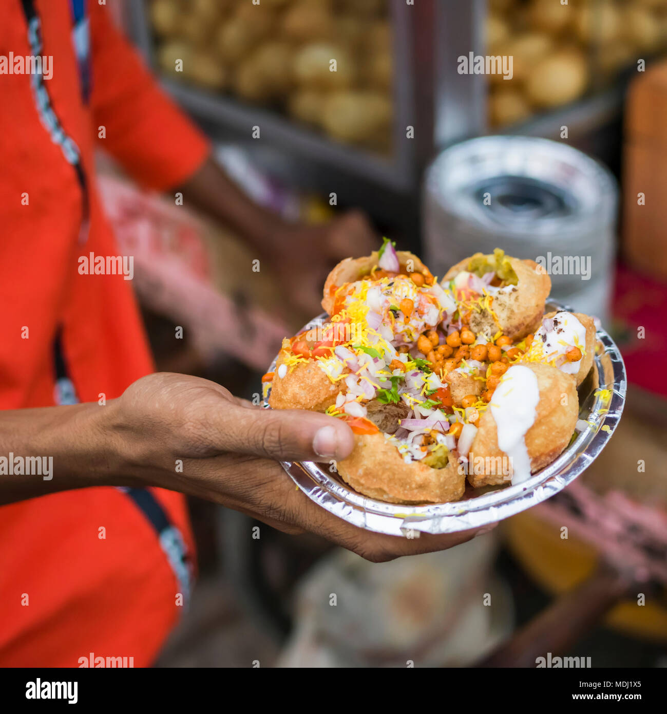Eine Hand mit einem Folie Platte mit einer Umhüllung des traditionellen indischen Essen, Jaipur, Rajasthan, Indien Stockfoto