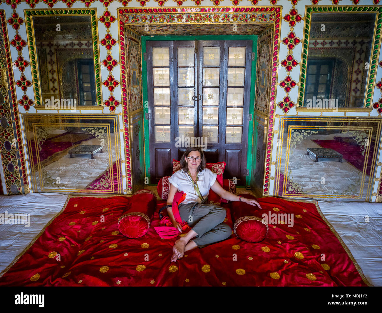 Eine weibliche Touristische sitzt auf der luxuriösen roten Teppich auf dem Boden der Stadt Palast, Maharaja Sawai Mansingh II.-Museum, Mubarak Mahal Stockfoto