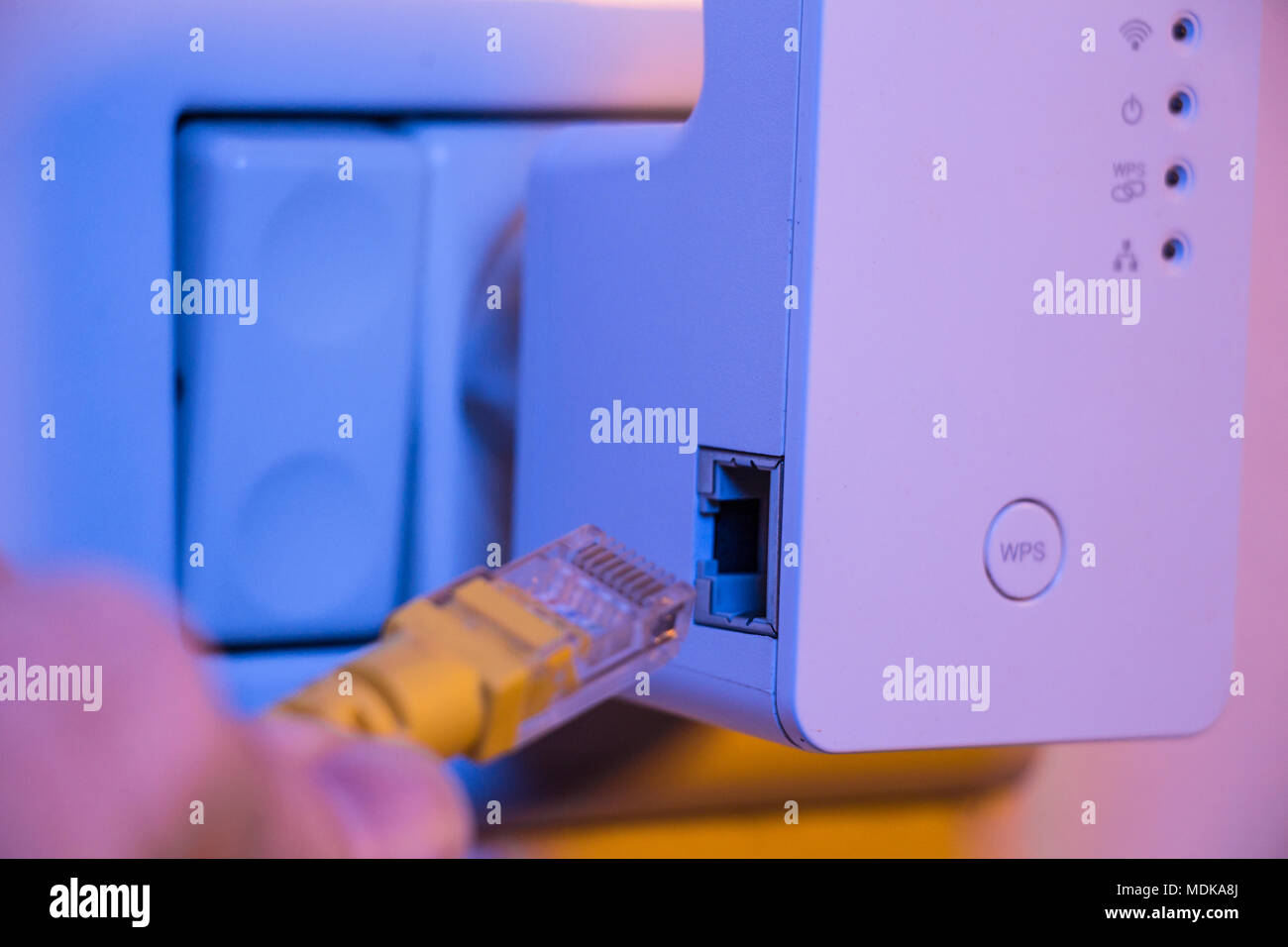 Man Ethernet-Kabel in WiFi Extender gerät das in der Steckdose an der Wand ist. Das Gerät ist im Access Point Modus, die helfen, zu verlängern. Stockfoto