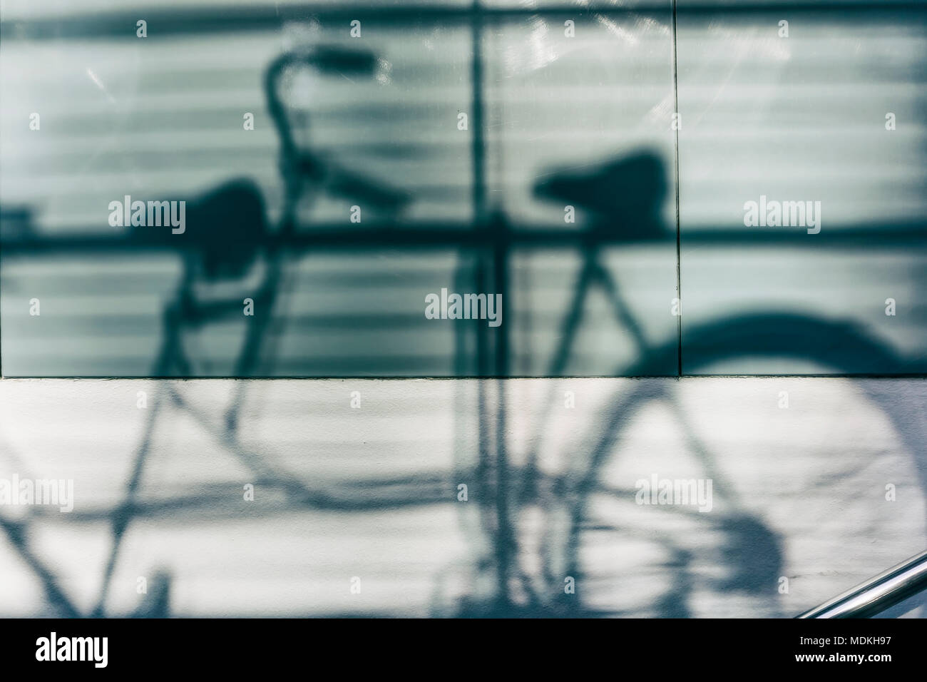 Schatten von zwei Fahrrädern auf Glas Wand Stockfoto